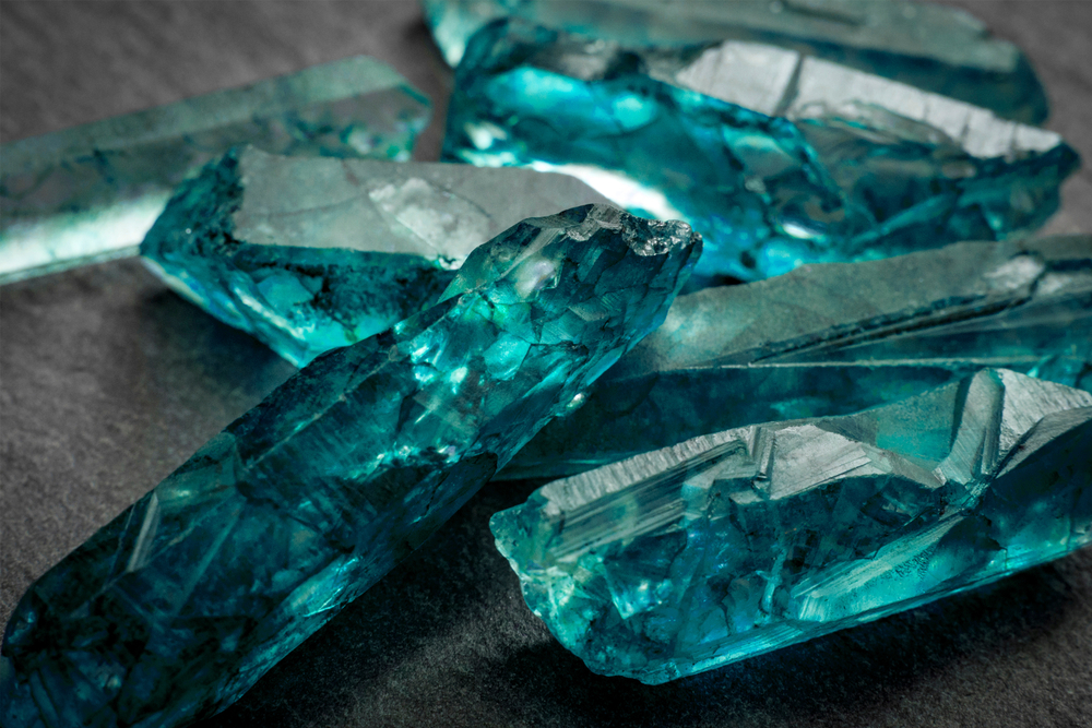 aquamarines-and-raw-crystal-gems-concept-with-closeup-of-a-bunch-of-blue-uncut-aquamarine-topaz-or-t-792228910